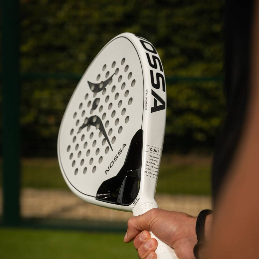 Player holding the white NOSSA Padel CORE racket outdoors