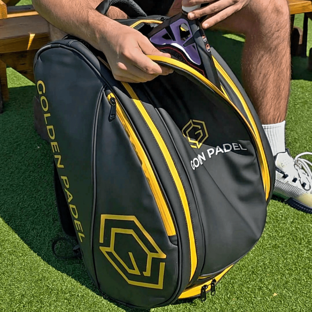 Player unzipping the Golden Padel Pro Tour backpack on a padel court