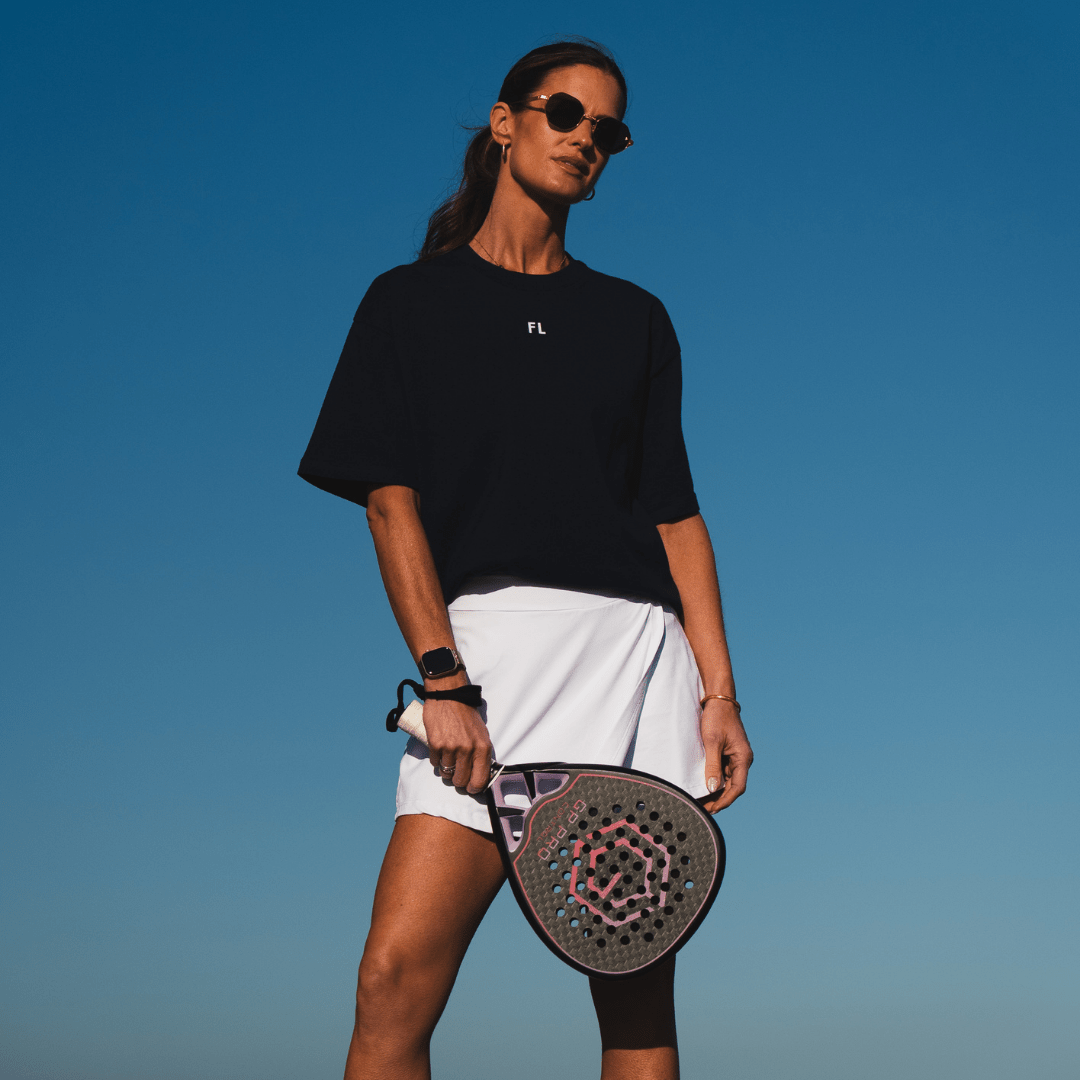 Woman holding the Golden Padel GP Pro Control racket against a blue sky